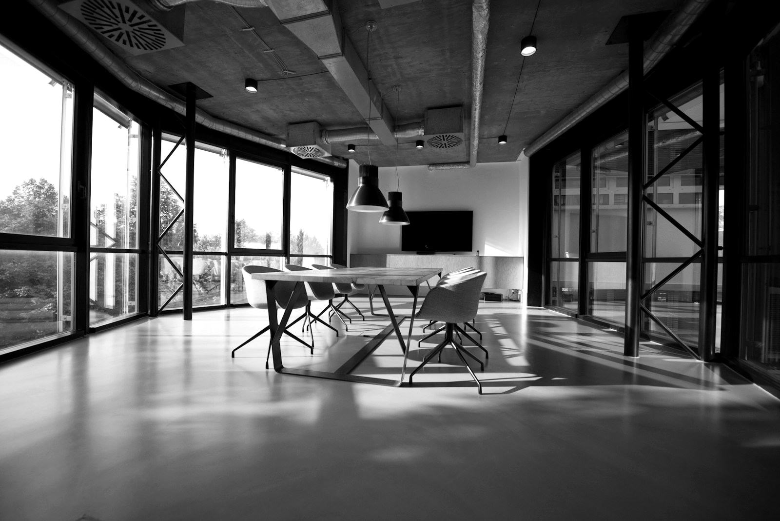 Modern conference room with a long table, glass walls, and institutional architecture