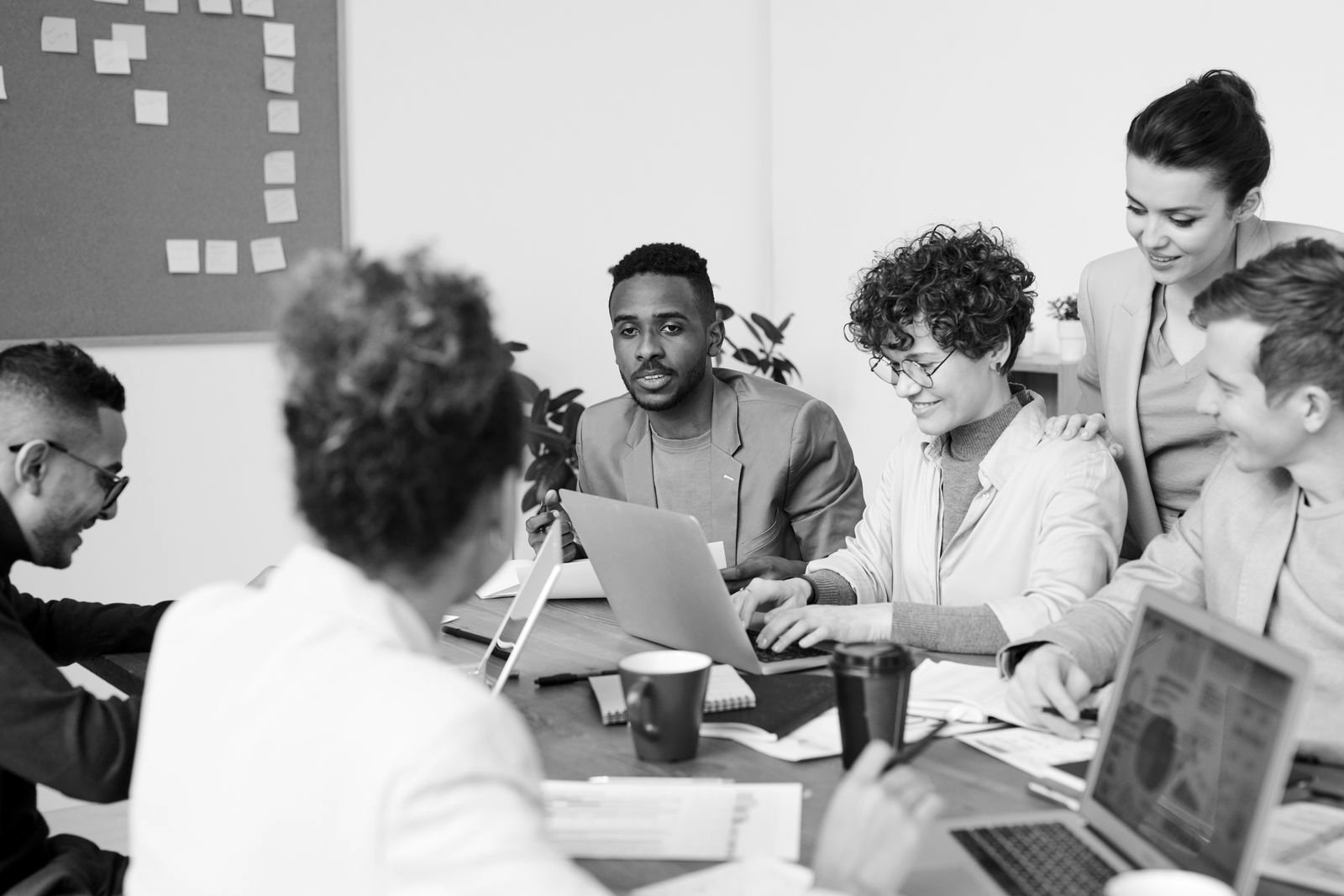 Consultant in a blazer meeting with clients around a conference table