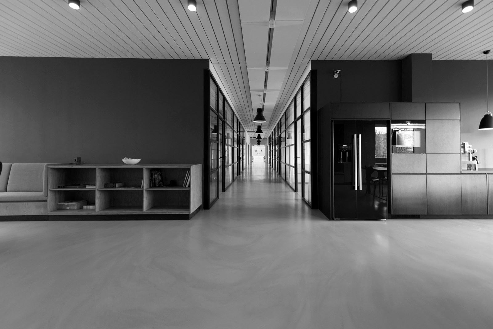 Modern institutional office corridor with glass partitions and polished floors